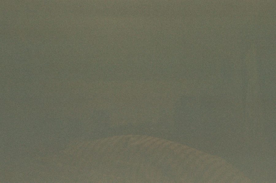 A very dim and nearly unrecognizable photo with faint outlines of what might be a bed or furniture, but the details are obscured due to low light.