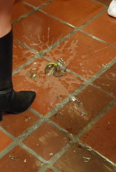 A broken wine glass on the floor.