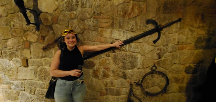 Ava with a longsword in the weapons room of Castello di Amorosa.